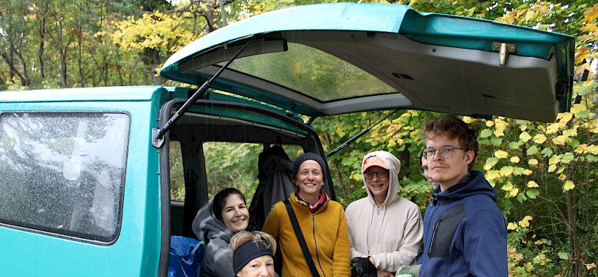 Menschen stehen unter einem Kofferraumdeckel