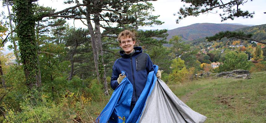 Mann trägt Plane mit Schnittgut