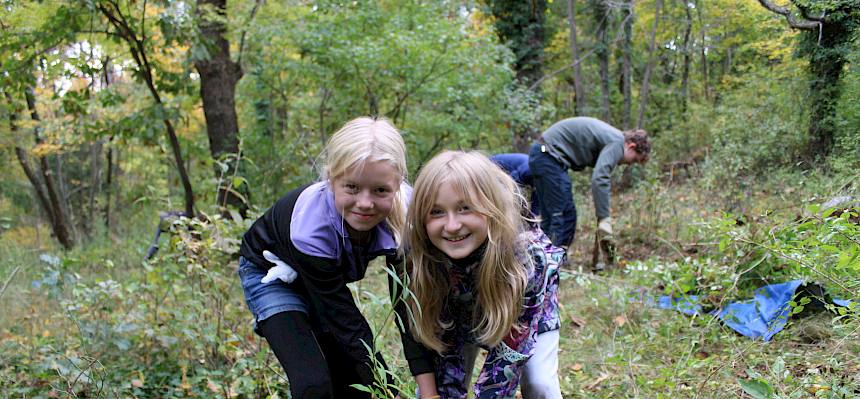 Zwei Mädchen stehen bei einem Busch