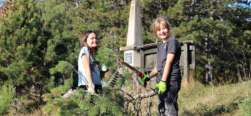 Mädchen tragen Ast einer Föhre