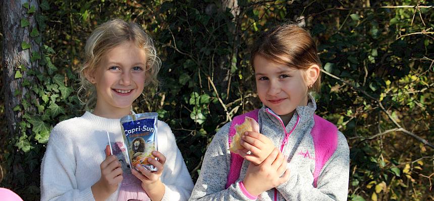 Kinder essen Semmeln und trinken Capri Sonne