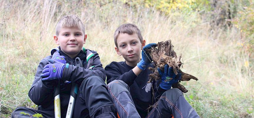 Kinder mit ausgegrabener Wurzel