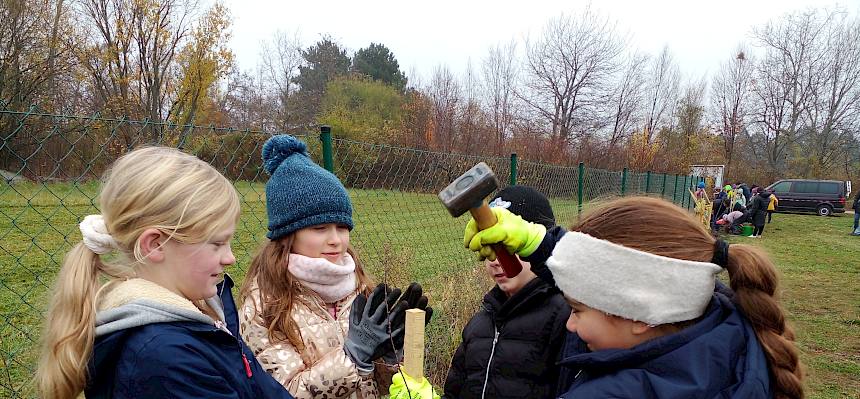 Schülerinnen schlagen Pflock ein