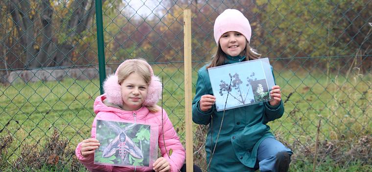Schülerinnen mit gepflanztem Strauch und Folie
