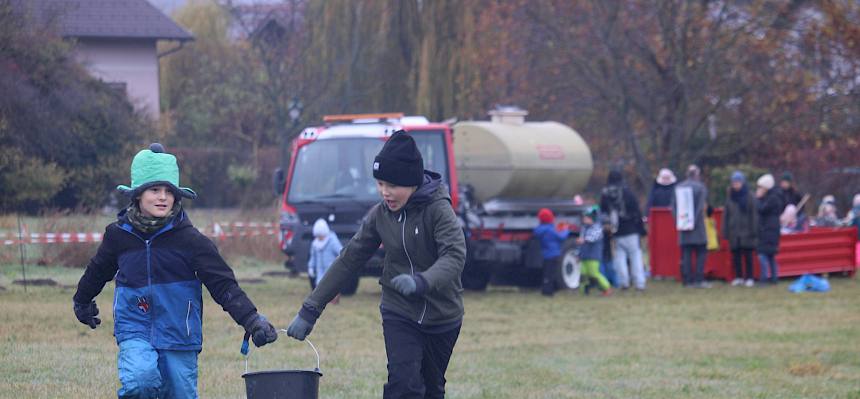 Schüler tragen Kübel mit Erde gemeinsam