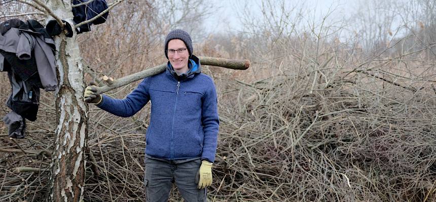 Freiwilliger trägt Ast
