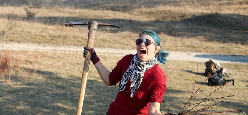 Mensch mit Krampen und Gehölz