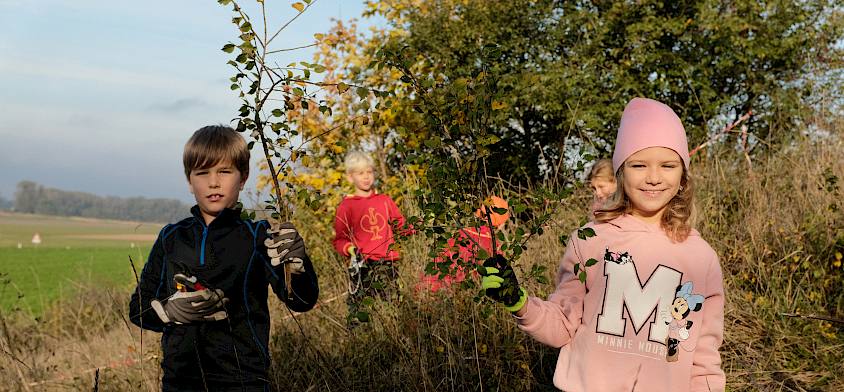 Kinder mit Scheren und Ästen