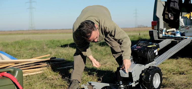 Maschinen und Werkzeug zur Landschaftspflege brauchen regelmäßige Wartung und Reparatur. Immer wieder auch spontan bei der Pflege vor Ort. © LPV/J. FFischer Mann repariert Balkenmäher
