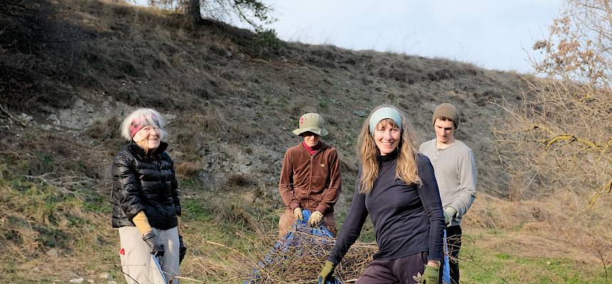 Freiwillige tragen Plane mit Schnittgut