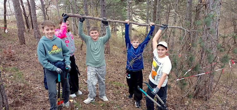 Schüler:innen halten Ast in die Höhe