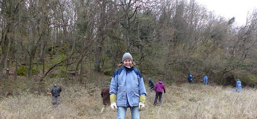Freiwillige hinter Plane mit Schnittgut
