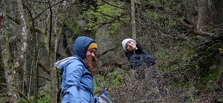 Freiwillige tragen Plane mit Schnittgut