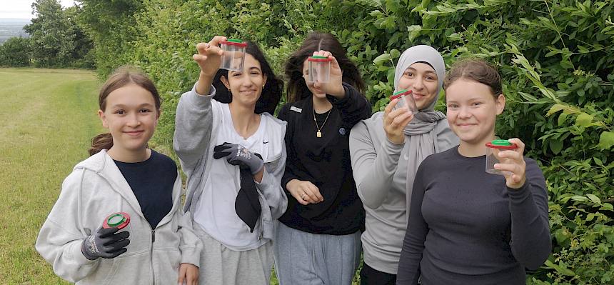 Gruppe Jugendlicher mit Becherlupen