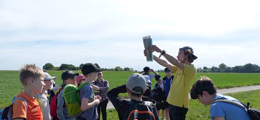 Naturvermittler zeigt Kindern Folie