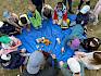 Mithilfe ansprechender Gegenstände wurden die Entstehung, die Besonderheiten und die Spielregeln von Wiesen erarbeitet. © LPV/H. Sommer Kinder im Sitzkreis um Wiesen-Gegenstände