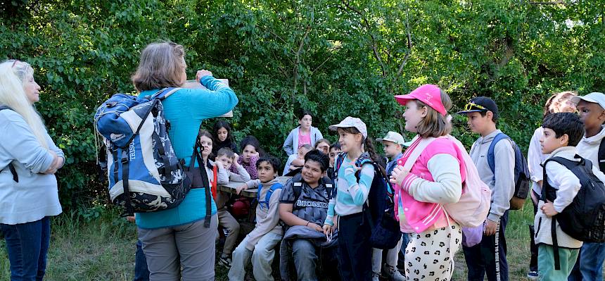 Naturvermittlerin zeigt Kindern Folien
