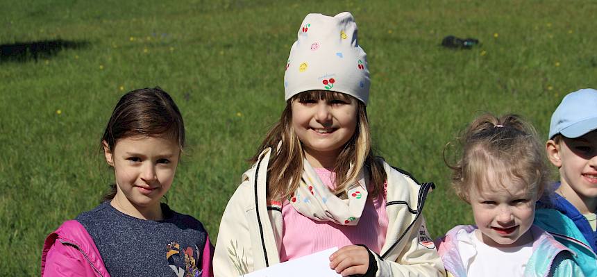 Kinder präsentieren ihr Wiesenklebebild