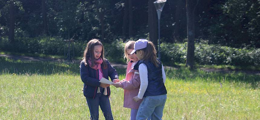 Kinder erstellen ein Wiesenklebebild