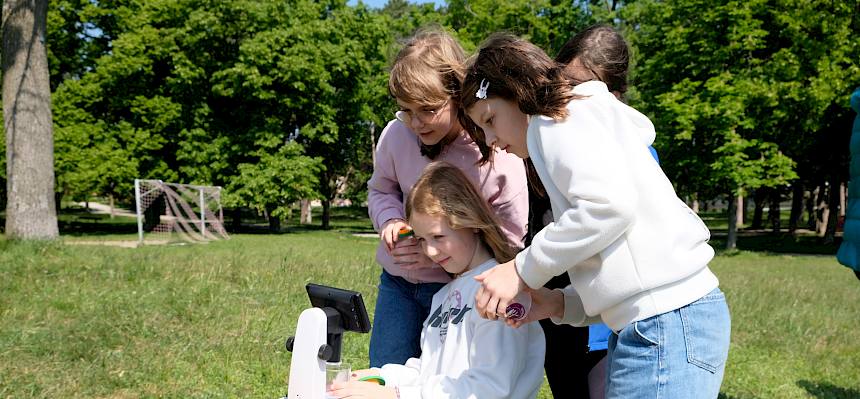 Kinder betrachten ein Insekt durch ein Binokular