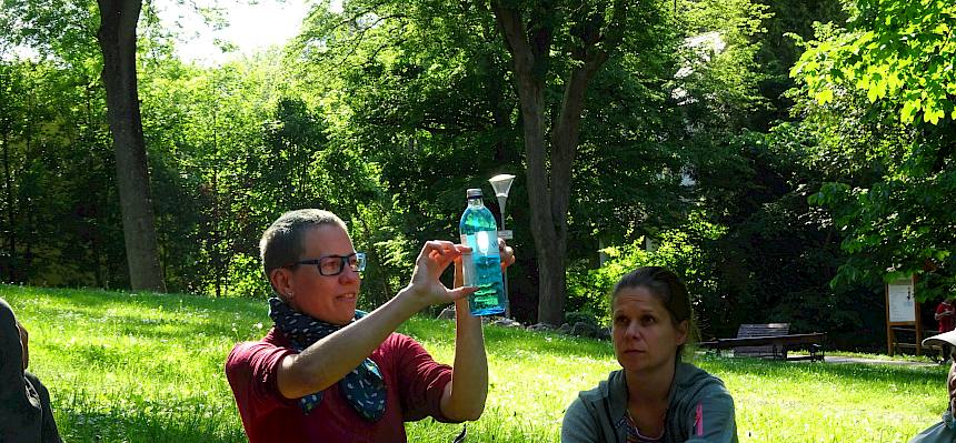 Naturvermittler:in zeigt Vergleich Menge Wasser auf der Erde