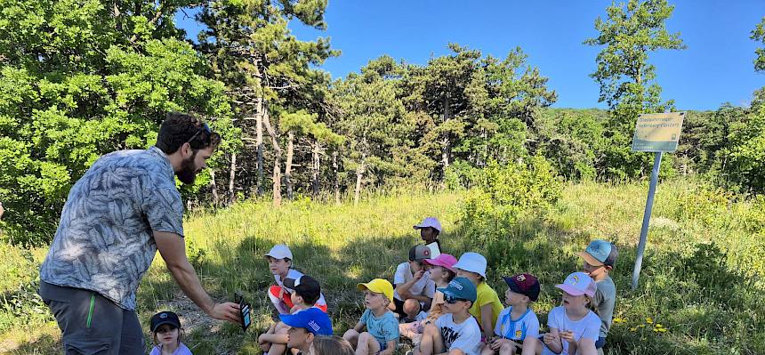 Natuvermittler zeigt Kindern Foto