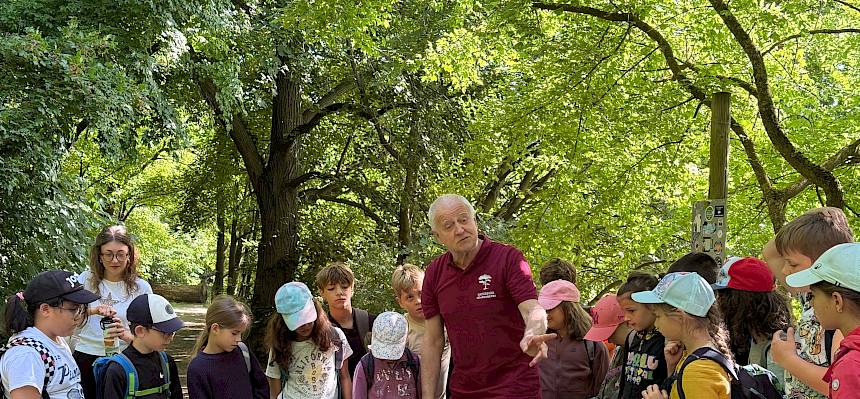 Kinder im Halbkreis um Konrad Brunnhofer