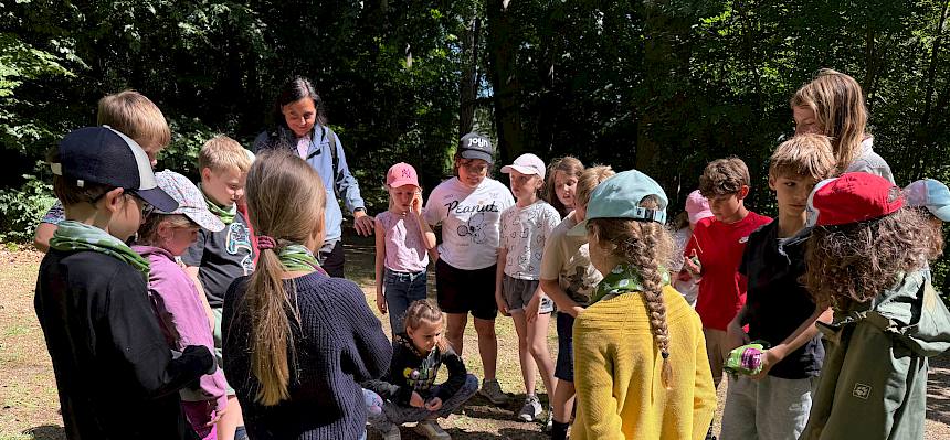 Kinder stehen im Kreis um Gegenstände