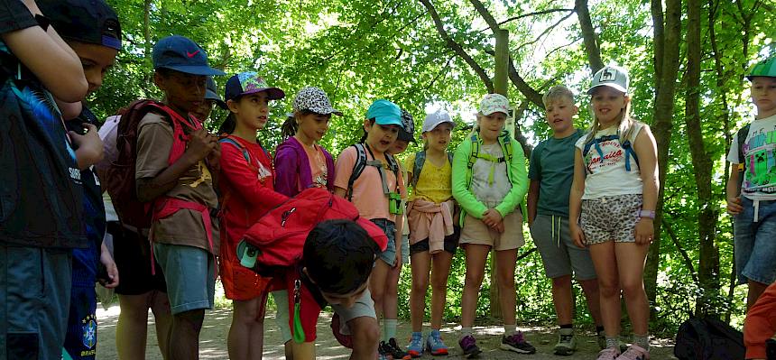 Kinder im Halbkreis um Konrad Brunnhofer