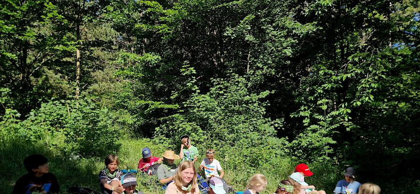 Kinder sitzen auf Lichtung
