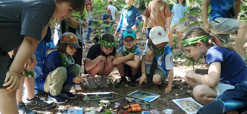 Kinder im Kreis um Gegenstände