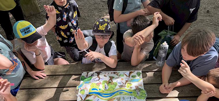 Mithilfe einer Magnettafel wurden die Unterschiede zwischen Urwald, naturnahem Wald und intensiv genutztem Wirtschaftswald gemeinsam erarbeitet. © LPV/H. Sommer KInder mit Magnettafel