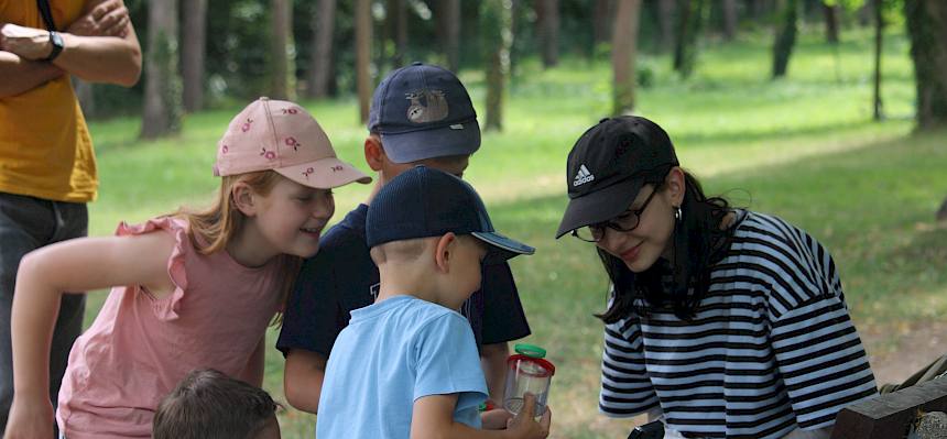 Kinder betrachten Tier in Becherlupe