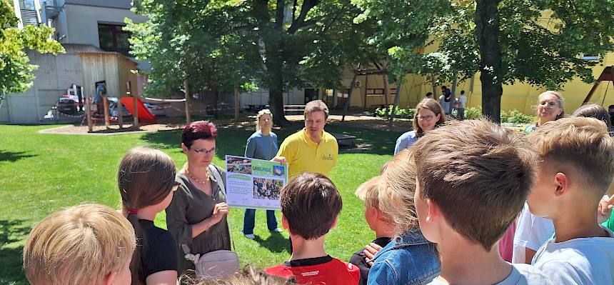 Biologe überreicht Urkunde an Schüler:innen