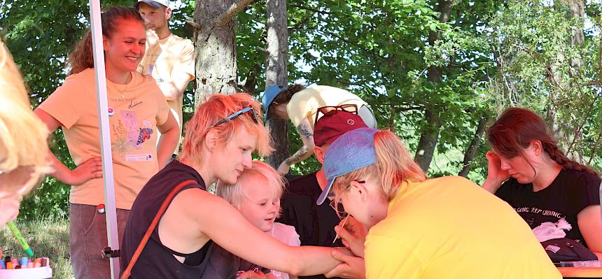 Naturvermittler:in malt mit Kinderschminke