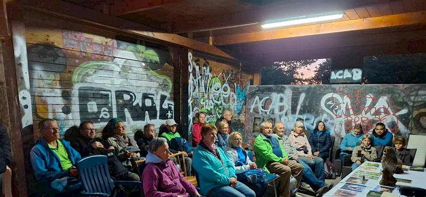 Gruppe sitzt und hört Biologin zu
