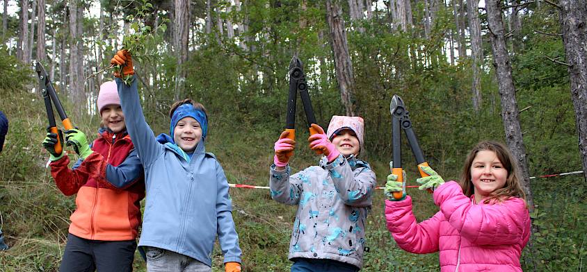Lachende Kinder mit Astscheren
