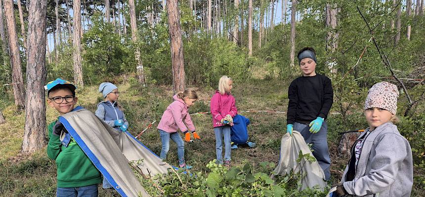 Kinder tragen Schnittgut